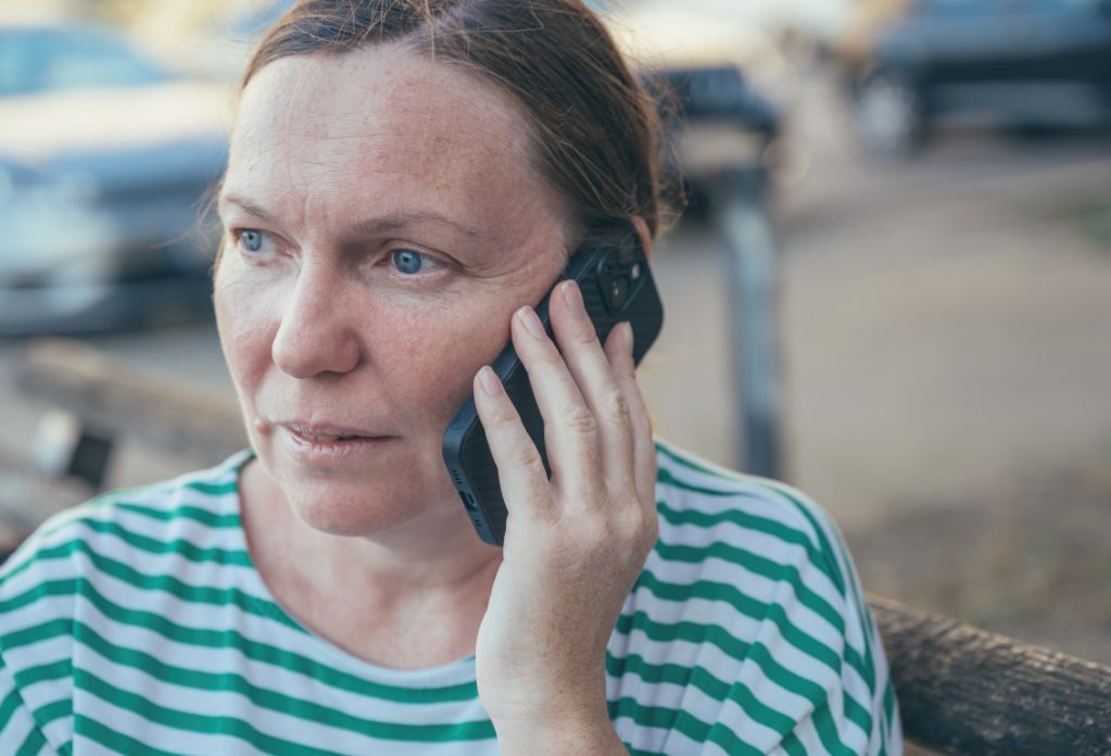 distressed woman on the phone. big give christmas appeal 2023 - double your donation for free