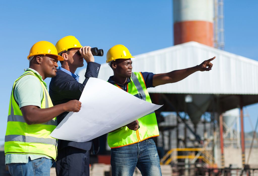 A diverse group of construction workers on site. One of them is holding a site map. 10 ways to strengthen your modern slavery statement in construction