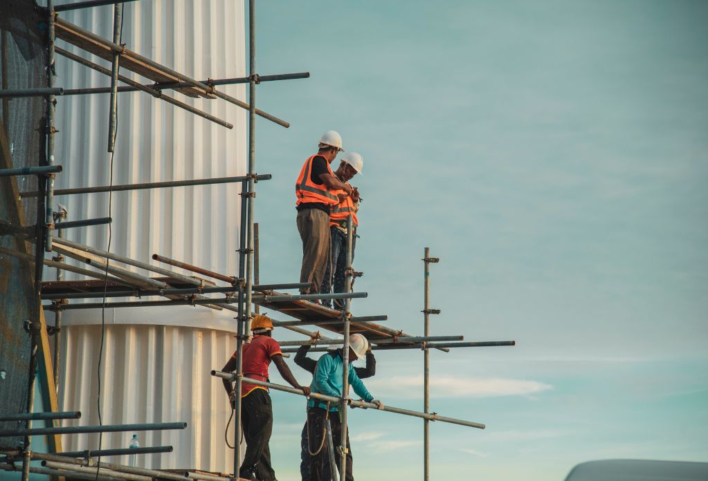 A group of construction workers standing on scaffolding. 10 ways to strengthen your modern slavery statement in construction