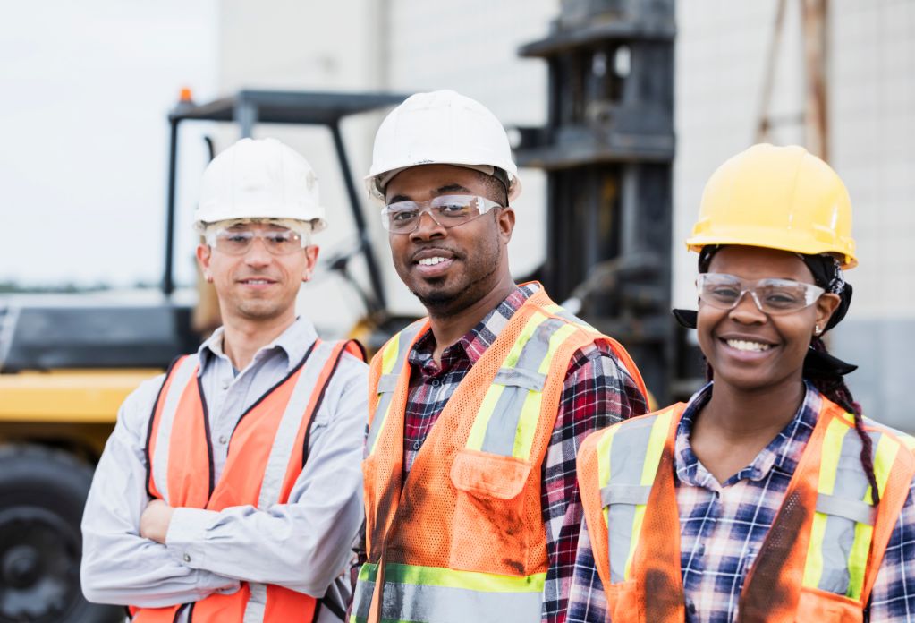 three diverse construction workers smiling to the camera. 10 ways to strengthen your modern slavery statement in construction
