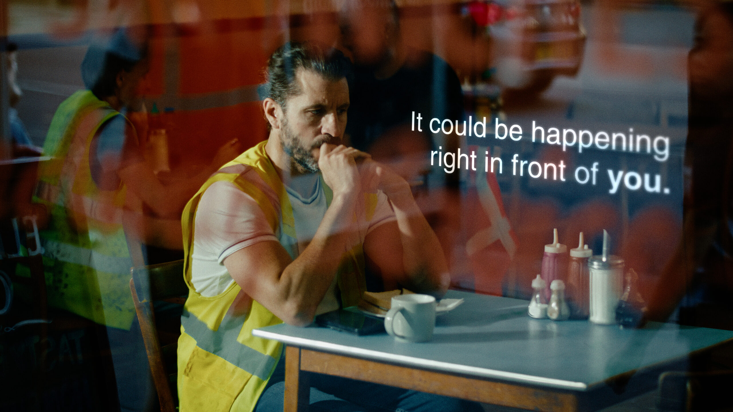 worker sits in a cafe with text revealing modern slavery in construction