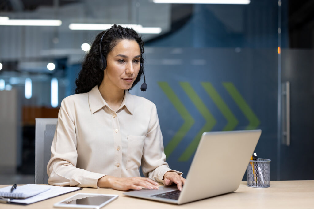 Unseen Annual Assessment webinar promotion. Woman with headset answers calls to the Modern Slavery & Exploitation Helpline.